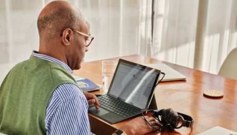 Image of man wearing glasses looking at computer